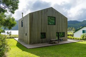 蓬塔德尔加达Sete Cidades Lake Cabin - Casa da Lagoa的草坪上带长凳的木屋