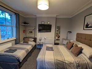 雷丁Caversham Lodge的客房设有三张床和一台平面电视。