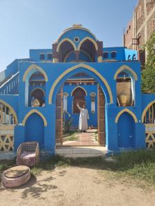 卢克索A R A B I A Golden Palace的蓝色的建筑,有一位女士站在门口