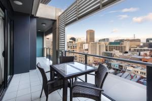 阿德莱德Oaks Adelaide Horizons Suites的市景阳台配有桌椅。