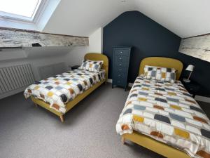 Port Saint Mary卡里克客房酒店的卧室设有两张单人床和蓝色的墙壁
