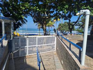 瓜鲁雅Duplex pé na areia, praia do Tombo - Guarujá/SP.的海边的白色围栏