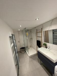 马赛Appartement Design sur Vauban - Clim et Wifi的浴室配有盥洗盆、镜子和浴缸