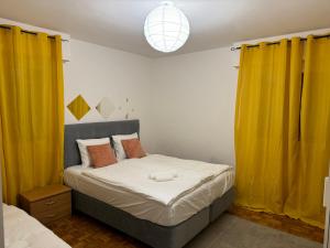洛桑Apartahotel Confort的一间卧室配有黄色窗帘的床