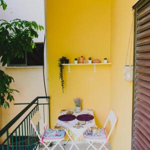 美西尼Relaxation apartment的阳台设有一张桌子和椅子,阳台设有黄色的墙壁