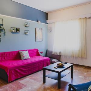 美西尼Relaxation apartment的客厅配有粉红色的沙发和桌子