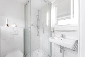 博尔库姆Auszeit Borkum的带淋浴和盥洗盆的白色浴室