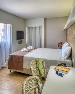 马塞约Hotel Costamar Ponta Verde的酒店客房带一张床、一张桌子和椅子