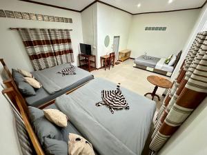 清刊บ้านคุณโต้ง เชียงคาน BaanKhunTong ChiangKhan的带两张床的房间和客厅