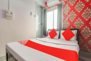兰奇OYO Oxy Rudra Inn的窗户客房内的一张红白色的床