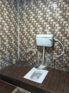 瓦拉纳西Hotel Regard的瓷砖墙前带卫生间的浴室