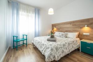 卡塔赫纳CARTAGENAFLATS, Piso Moderno 3 Dormitorios, Cartagena Center的一间卧室配有一张床和一张蓝色椅子