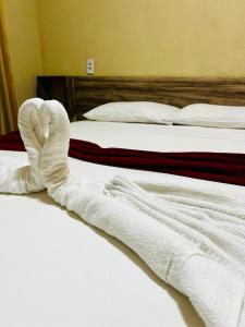 福塔莱萨El Dorado Hotel Fortaleza的两张床,上面摆放着白色毛巾