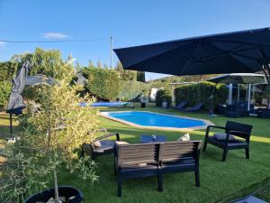 卡布列斯埃塔普普罗文卡勒酒店的一个带椅子和遮阳伞的庭院和游泳池