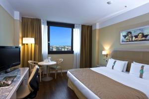 那不勒斯那不勒斯假日酒店的一间设有大床和窗户的酒店客房