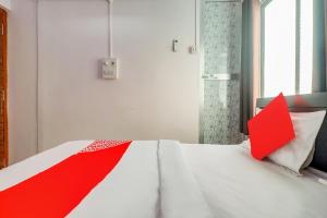 兰奇OYO Oxy Rudra Inn的卧室配有白色床铺上的红色枕头