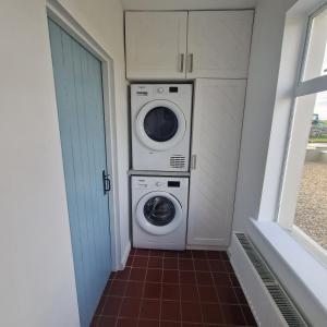 Knockfin Cross RoadsCoastal Charm Cottage的洗衣房配有洗衣机和烘干机