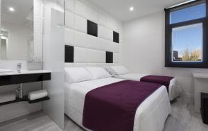 富恩拉夫拉达Hoteles Urbanos N Avenida de España的白色卧室设有床铺和水槽