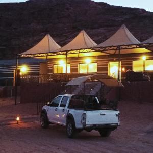 瓦迪拉姆Miral Night Camp的一辆夜间停在房子前面的白色卡车