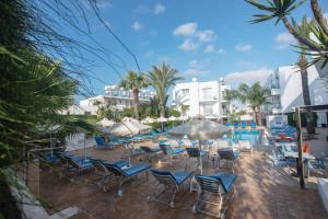 阿依纳帕帕富力尼亚公寓酒店的一个带椅子的庭院和一个棕榈树游泳池
