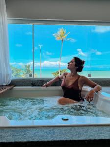 若昂佩索阿Kastel Jampa Hotel的浴缸里的妇女,享有海景