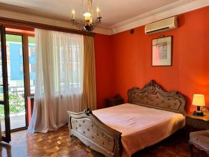 巴统Guesthouse Parnavaz Mepe的一间卧室拥有橙色的墙壁、一张床和窗户