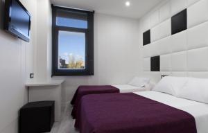 富恩拉夫拉达Hoteles Urbanos N Avenida de España的一间卧室设有两张床和窗户。