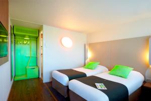 里永克莱蒙费朗～里永钟楼酒店的客房 - 带两张带绿色枕头的床