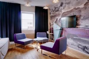 延雪平延雪平康福特酒店的一间设有两张紫色椅子和电视的房间