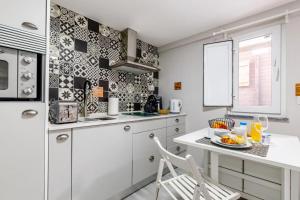 新皮尼亚尔Chalé do Vale的白色的厨房配有桌子和椅子
