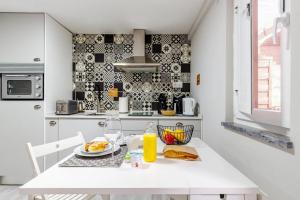 新皮尼亚尔Chalé do Vale的白色的厨房,配有一张桌子和一盘食物