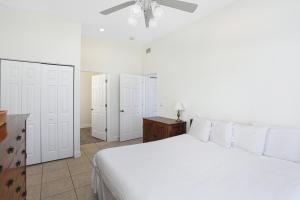 Cape San BlasLa Mer by Pristine Properties Vacation Rentals的卧室配有白色的床和吊扇