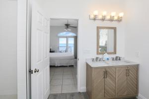 Cape San BlasLa Mer by Pristine Properties Vacation Rentals的一间带水槽和镜子的浴室以及一张床