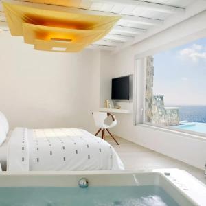 米克诺斯城Gorgeous Villa BR Suite Astonishing Sea View的一间带浴缸、床和窗户的卧室