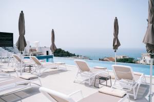 乌尔齐尼Padam Hotel & SPA的一个带白色椅子和游泳池的庭院