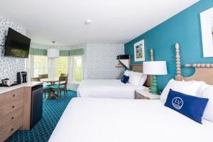 麦基诺岛湖景酒店的酒店客房设有两张床和一张桌子。