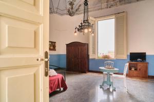 米内尔维诺迪莱切Palazzo Scarciglia的客房设有桌子、椅子和窗户。