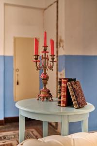 米内尔维诺迪莱切Palazzo Scarciglia的一张带蜡烛的桌子和上面的书籍