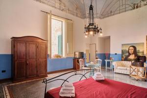 米内尔维诺迪莱切Palazzo Scarciglia的客厅配有红色的床和吊灯。