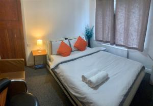 曼彻斯特Stay Inn M30的卧室配有带橙色枕头的白色床