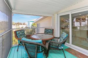 Cape San BlasCape Haus by Pristine Properties Vacation Rentals的阳台的天井配有桌椅