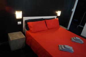 里米尼Stupido Hotel Rimini的一间卧室配有红色的床和红色枕头