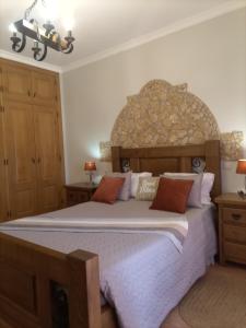阿尔戈什梅萨维拉酒店的一间卧室配有一张大床和石制床头板