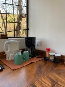 奥科塔尔Guesthouse Casa Avi Fauna的咖啡壶和杯子,坐在木地板上