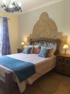 阿尔戈什梅萨维拉酒店的一间卧室配有一张大床和大床头板