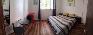 瓦尔帕莱索波旅舍的一间卧室配有一张床、一张书桌和一个窗户。