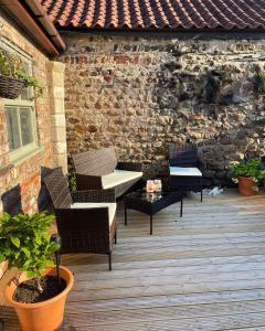 里彭Swallow Cottage的一个带桌椅的庭院和砖墙