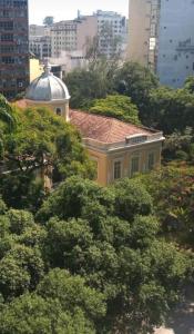 尼泰罗伊Loft Aconchegante no Centro de Niterói!!的被树木包围的黄色建筑
