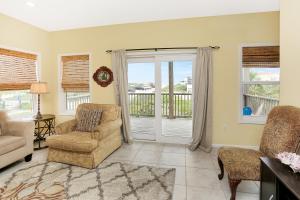 Cape San BlasReveille by Pristine Properties Vacation Rentals的客厅配有椅子、沙发和窗户