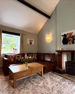 里彭Swallow Cottage的客厅配有沙发和桌子